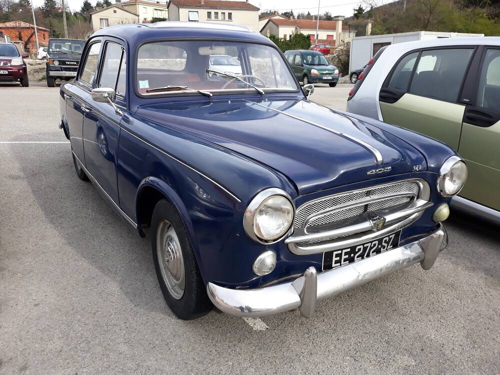 Une Peugeot 403 bleu nuit garée dans une rue